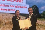 Bundesminister Cem Özdemir überreicht der Gewinnerin des GFFA-ScienceSlams, Lia Orr, die Siegerurkunde.