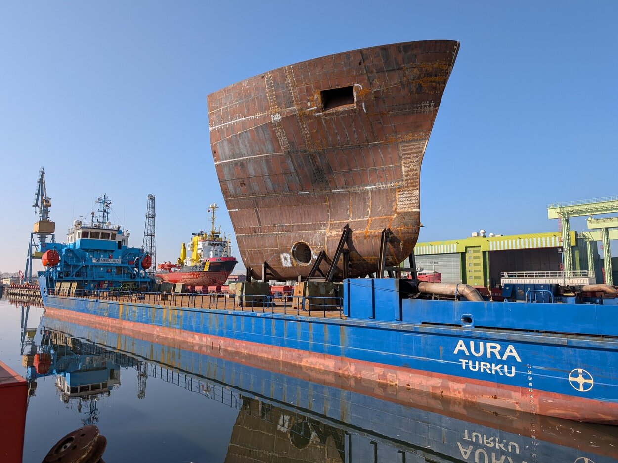 Ein blauer Frachter bringt ein Bugsegment zur Werft.