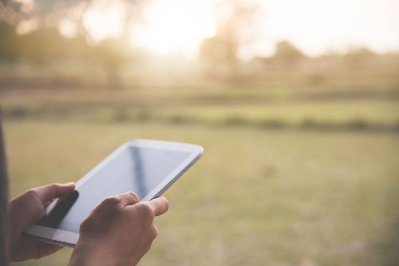 Use of a tablet on countryside background