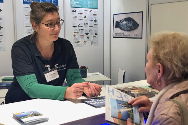 Gespräch mit einer Besucherin am Fisch-Stand.