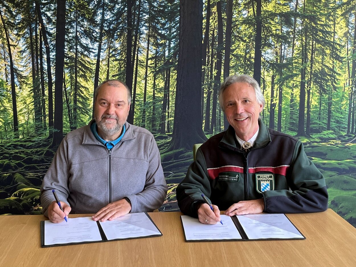 Prof. Dr. Andreas Bolte, Leiter des Thünen-Instituts für Waldökosysteme, und Dr. Peter Pröbstle, Präsident LWF, unterzeichnen gemeinsam die Kooperationsvereinbarung. Zwei Personen sitzen an einem Tisch und unterschreiben auf Papieren.