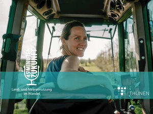 Eine Frau schaut aus dem hinteren Fenster eines Treckers.