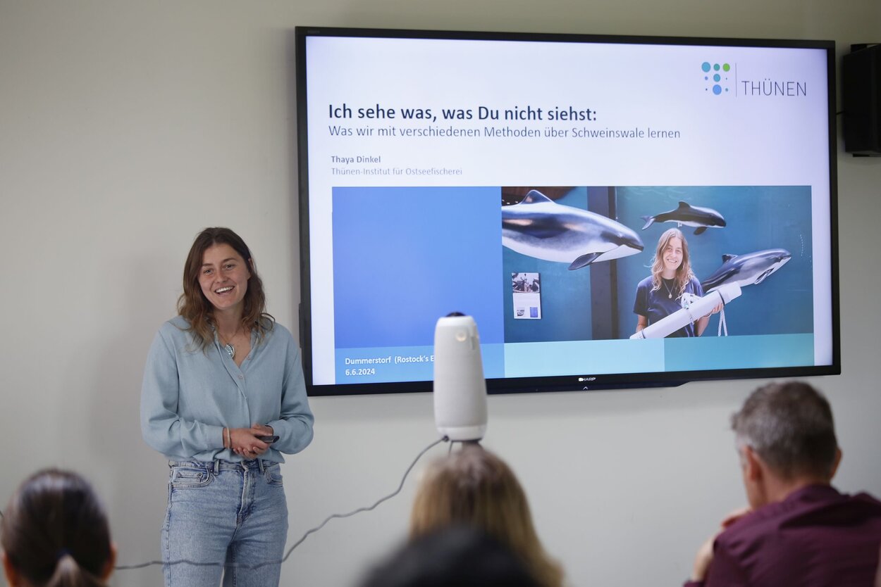 Thaya Dinkel steht neben ihrer Präsentation für Rostocks Eleven