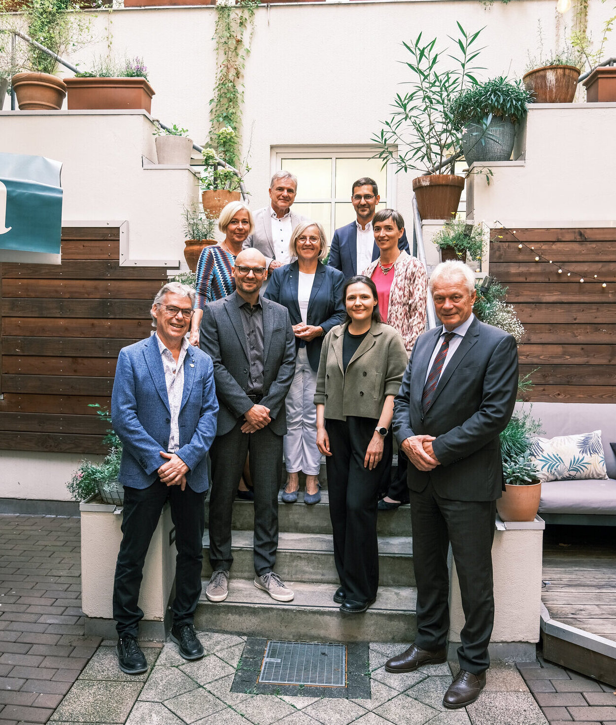 Nine people are standing on a staircase for a group photo.