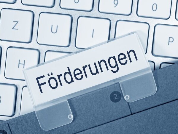 Ein Ordner mit der Beschriftung Förderung vorr einer Computertastatur