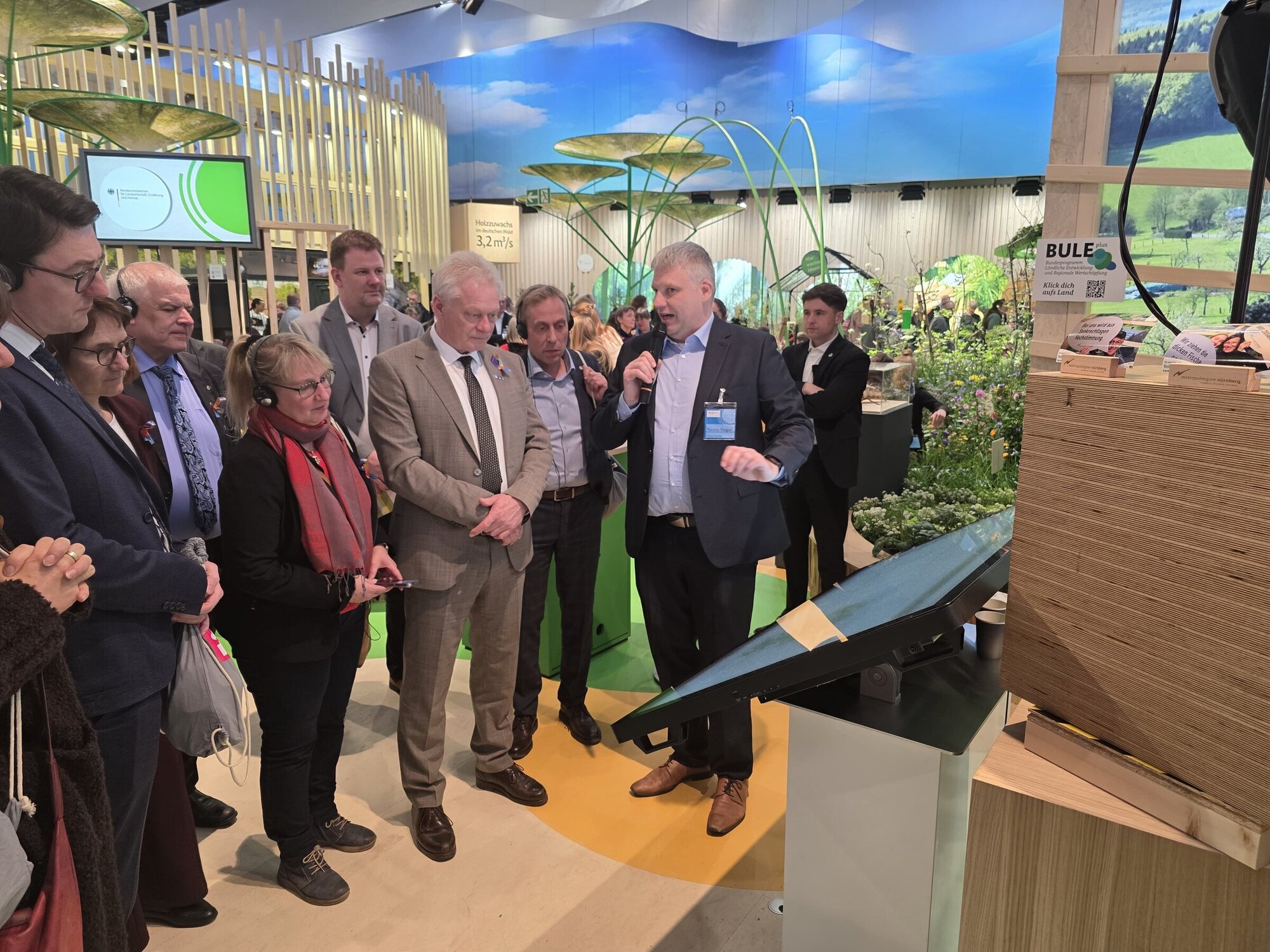 Der Agrarausschuss mit Landwirtschaftsminister Alois Rainer lässt sich von Torsten Osigus den Thünen-Landatlas zeigen.