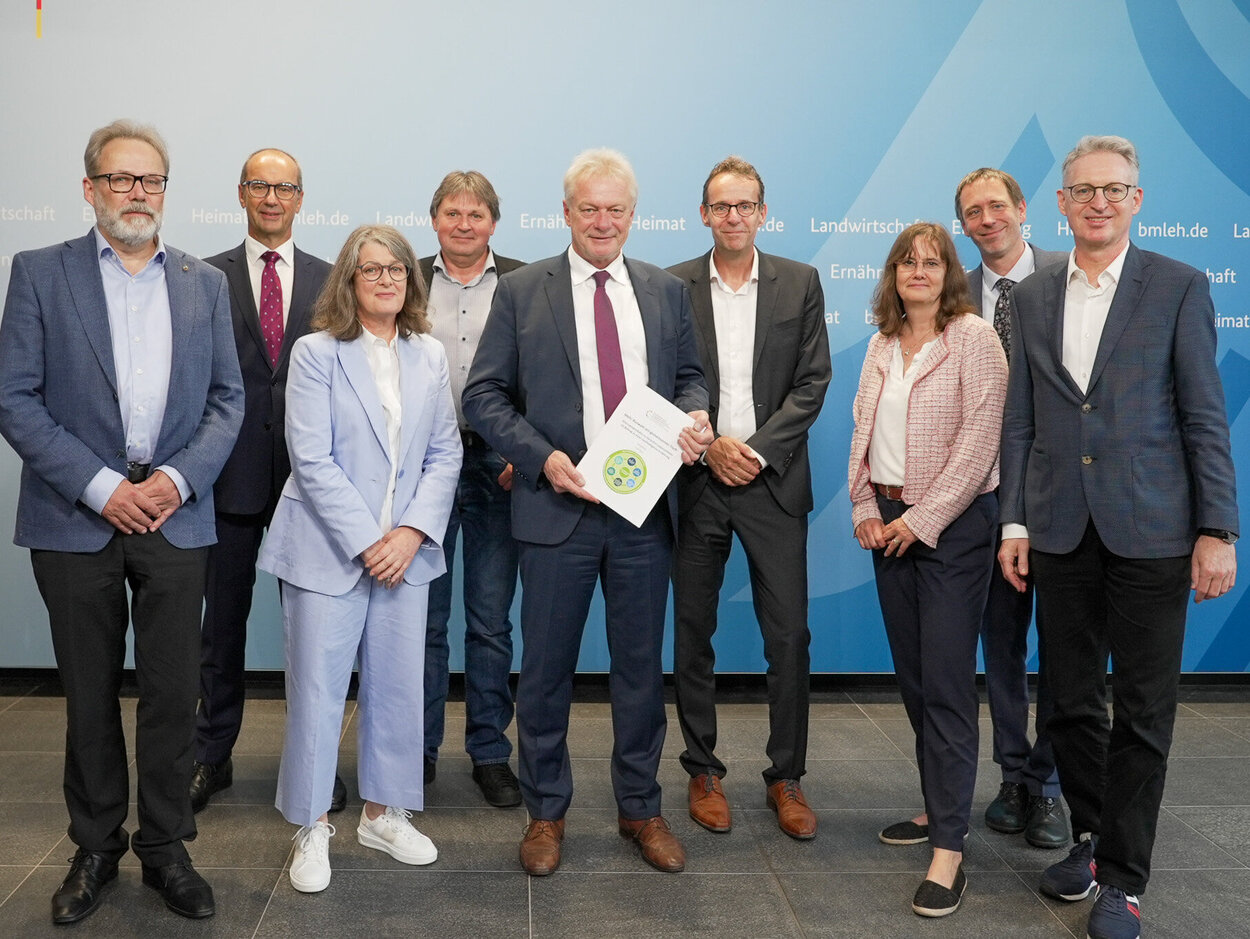 Mehrere Personen stehen vor einer Wand.