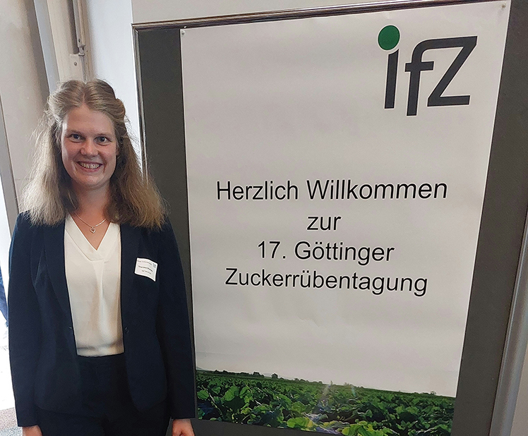 Theresa Brandes next to the display stand at the 17th Göttingen Sugar Beet Conference