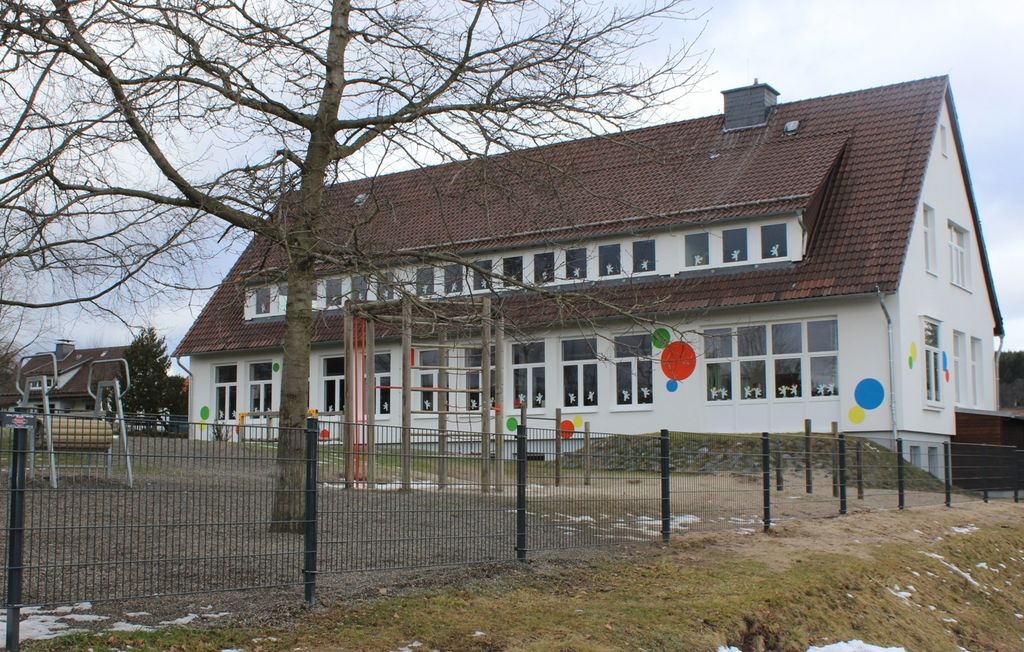 Außenansicht Schulgebäude mit eigenem Spielplatz