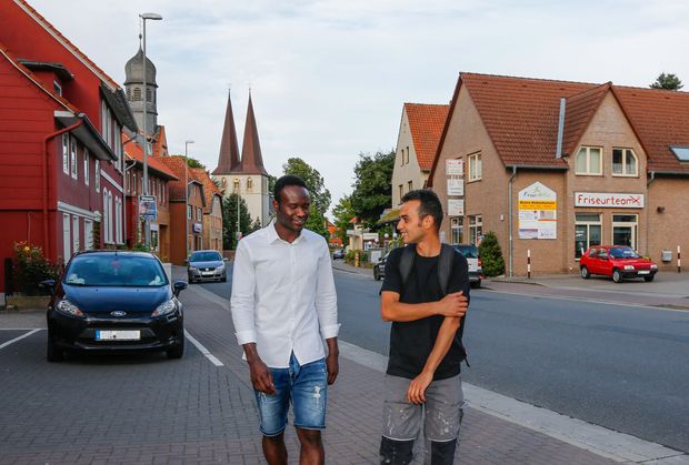 Two men with migrant background on a village street