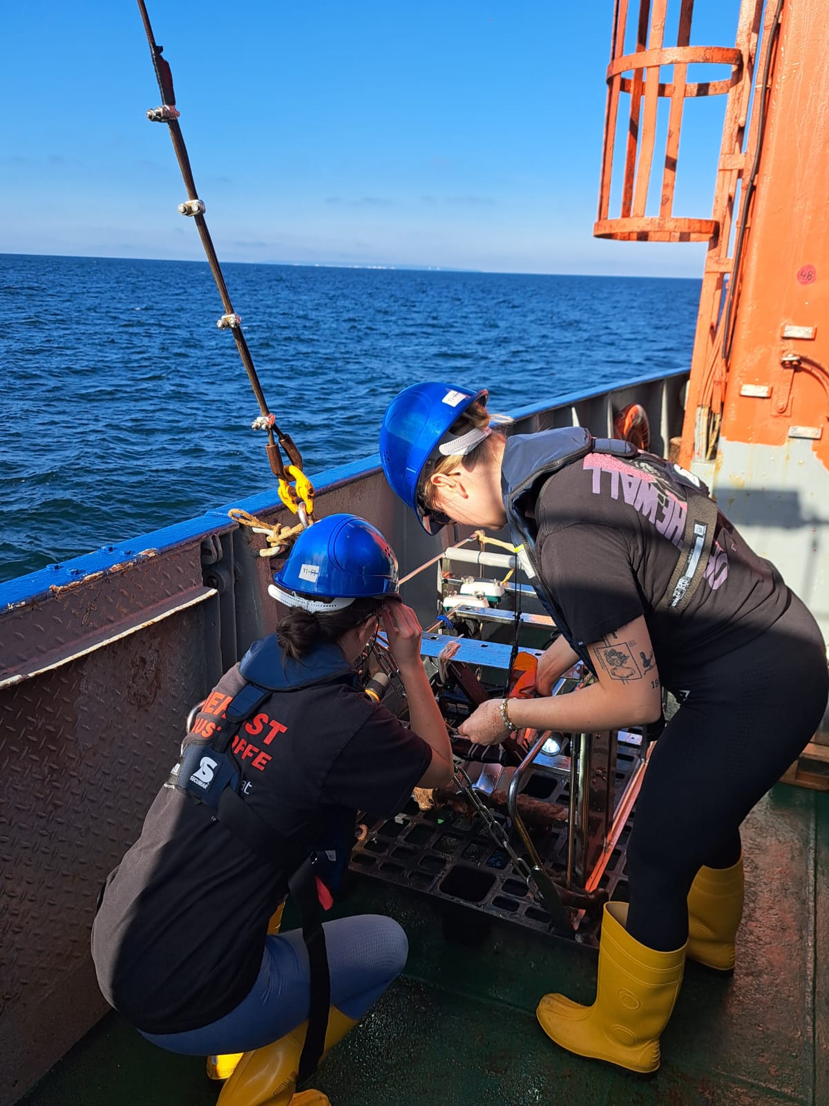 Two researchers prepare an underwater video sled for use.